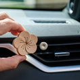Load image into Gallery viewer, Beechwood flower diffuser being placed on magnetic clip in car vent.