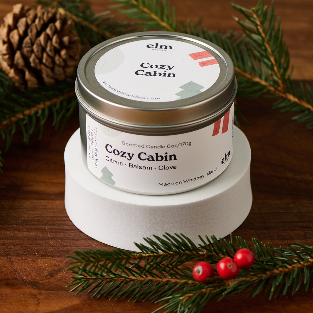 Elm Design's Cozy Cabin scented candle in an 6oz metal tin.