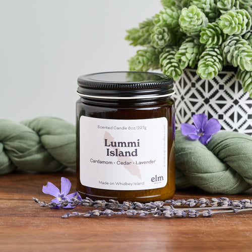 Elm Design Candles scented candle in Lummi Island scent in 8oz amber glass jar.