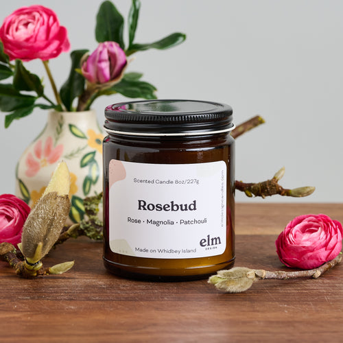 Elm Design Candles' scented candle Rosebud in an 8oz amber glass jar.