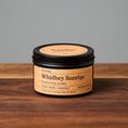 Load image into Gallery viewer, Whidbey Sunrise scented soy candle in black metal tin on wooden surface.
