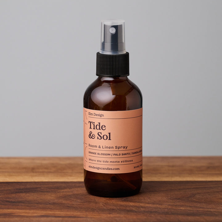 Tide & Sol scented room spray in amber glass jar on wooden surface.