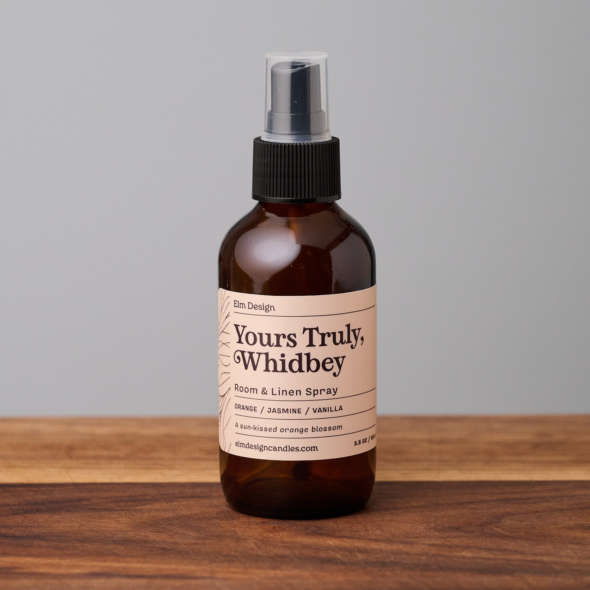 Yours Truly, Whidbey scented room spray in amber glass jar on wooden surface.