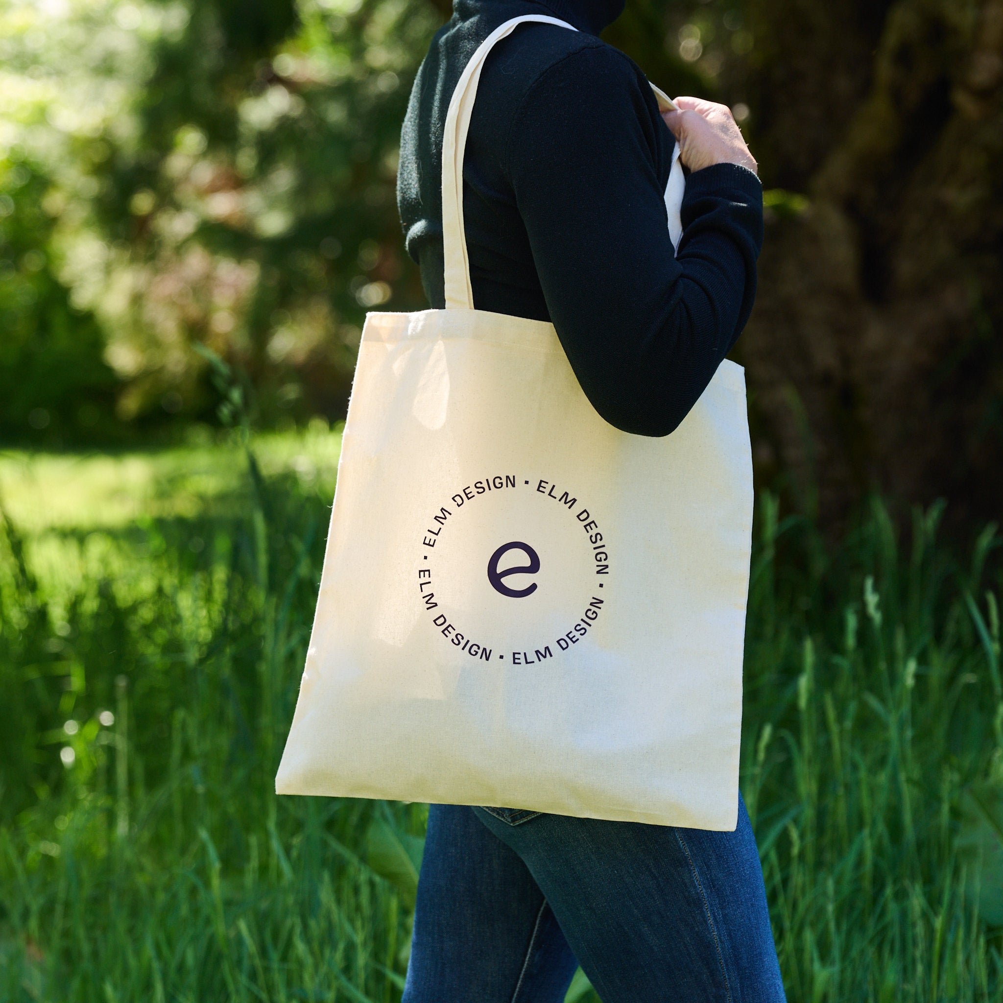 Canvas tote bag with Elm Design logo worn on shoulder