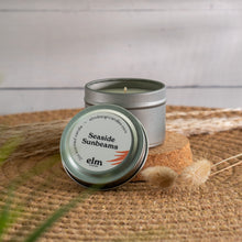 Load image into Gallery viewer, Seaside Sunbeams scented soy candle in colorfully labeled 2 oz container.
