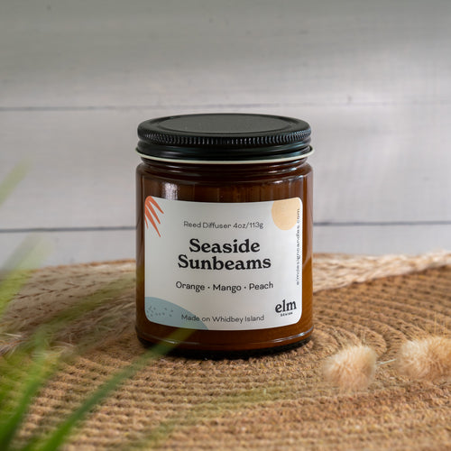 Seaside Sunbeams scented soy candle in colorfully labeled 8 oz container.