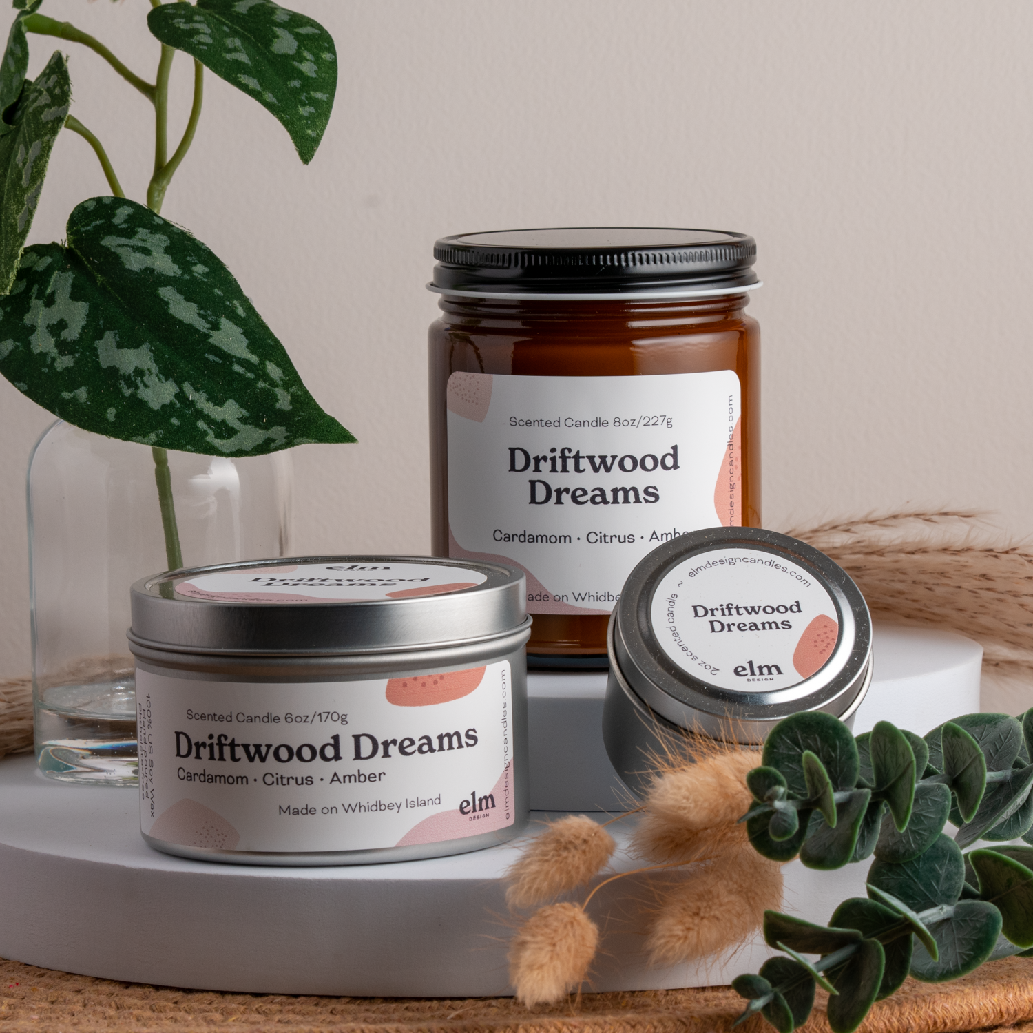 Driftwood Dreams scented soy candles in colorfully labeled 8, 6 and 2 oz containers.