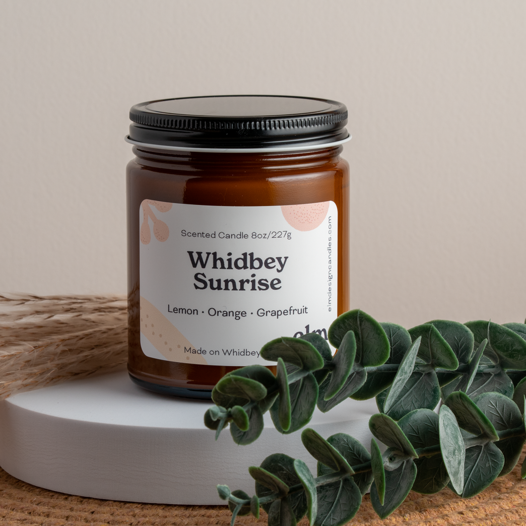 Whidbey Sunrise scented soy candle in colorfully labeled 8 oz container.