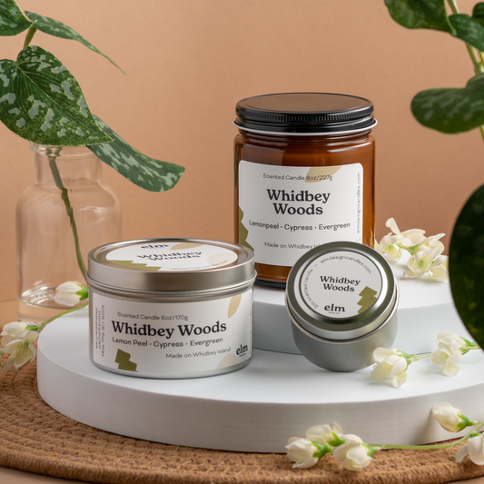 Whidbey Woods scented soy candles in colorfully labeled 8, 6 and 2 oz containers.