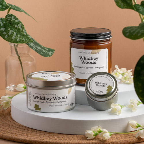 Whidbey Woods scented soy candles in colorfully labeled 8, 6 and 2 oz containers.